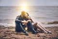 Young couple kisses in the rain. man and woman together on the seashore are holding a flashlight at sunset