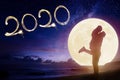 couple kissing on beach and watching the moon.Celebrate new year 2020 concept