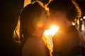 Young couple kissing in the flares of sunset light on a bridge c Royalty Free Stock Photo