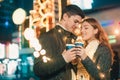 Young couple kissing and hugging outdoor in night street at christmas time Royalty Free Stock Photo