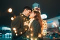 Young couple kissing and hugging outdoor in night street at christmas time Royalty Free Stock Photo