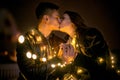 Young couple kissing and hugging outdoor in night street at christmas time Royalty Free Stock Photo