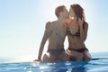 Young Couple Kissing in an Infinity Swimming Pool. Honeymoon Couple at Luxury Resort. Romantic Vacation. Royalty Free Stock Photo