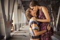 Young couple kissing in the summer daylight on a bridge construction in the city outdoors. copy space Royalty Free Stock Photo