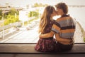 Young couple kissing in the summer daylight on a bridge construction in the city outdoors. copy space