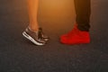 Young couple is kissing at sunset. Fashion sneakers close-up. Royalty Free Stock Photo