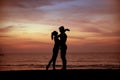 Young couple kissing on a tropical beach, sunset in background Royalty Free Stock Photo