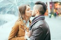 Young couple kissing under the rain during winter holidays shopping - Two lovers having tender moments during fall season - Love, Royalty Free Stock Photo