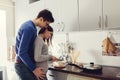 Young couple on kitchen hugging and cooking dinner.