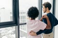 Romantic mixed race couple standing by the window thinking about their future. Royalty Free Stock Photo