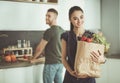 Young couple in the kitchen , woman with a bag of groceries shopping Royalty Free Stock Photo