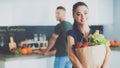 Young couple in the kitchen , woman with a bag of groceries shopping Royalty Free Stock Photo