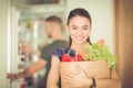 Young couple in the kitchen , woman with a bag of groceries shopping Royalty Free Stock Photo