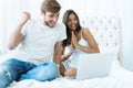 Young couple with laptop in the bed in room. Royalty Free Stock Photo