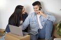 Young Couple With Laptop And Cellphone Purchasing Furniture Online After Moving Home Royalty Free Stock Photo