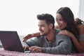 Young couple with laptop lying prone on carpet Royalty Free Stock Photo