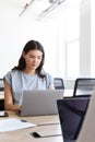 Young couple with laptops at desks working on start up business in rented open plan office space Royalty Free Stock Photo