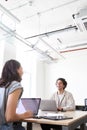 Young couple with laptops at desks working on start up business in rented open plan office space Royalty Free Stock Photo