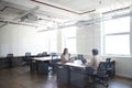 Young couple with laptops at desks working on start up business in rented open plan office space Royalty Free Stock Photo