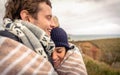 Young couple laughing outdoors under blanket in a Royalty Free Stock Photo