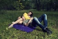 Young couple laying down on a purple blanket and listening music on a smartphone Royalty Free Stock Photo