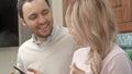 Young couple listening to music via smartphone, talking in the kitchen Royalty Free Stock Photo