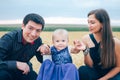 young couple with little child on the field