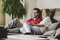 Couple watching TV on a sofa at home