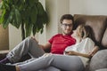 Couple watching TV on a sofa at home