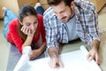 Young couple looking at the blueprints of their new home