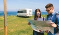 Young couple looking a map near the coast