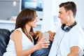 Young couple looking at mobile phone while sitting at home Royalty Free Stock Photo