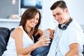 Young couple looking at mobile phone while sitting at home Royalty Free Stock Photo