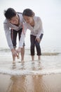 Young couple looking at seashells on the beach