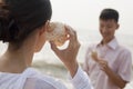 Young couple looking at seashells, holding shell to ear Royalty Free Stock Photo