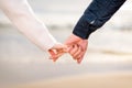 Young couple holding hands at sunset on beach. Romantic young couple enjoying beach. Couple on spring vacation.Closeup Royalty Free Stock Photo