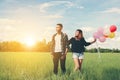 Young Couple in love with balloons in hands in the green grass b Royalty Free Stock Photo
