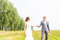 Young couple in love bride and groom posing in a field with yellow grass in their wedding day in the summer Royalty Free Stock Photo