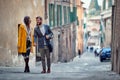 A young couple in love is chatting while enjoying a walk the old city by holding hands. Walk, rain, city, relationship Royalty Free Stock Photo