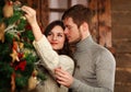 Young couple in love decorates Christmas tree at home Royalty Free Stock Photo