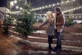 A young couple in love enjoying beautiful christmas festival on a snowy weather in the city. Christmas tree, love, relationship, Royalty Free Stock Photo