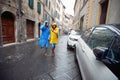 A young couple in love is enjoying a walk the city in raincoats during a rainy day. Walk, rain, city, relationship Royalty Free Stock Photo