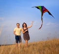 Young couple in love with flying a kite at countryside Royalty Free Stock Photo