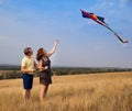 Young couple in love with flying a kite at countryside Royalty Free Stock Photo