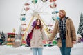 Young couple in love with a happy young man with a beard and a woman on a background of a colossus, a Ferris wheel resting