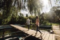 Young couple in love having fun with oars on the wooden bridge. stylish woman and man enjoy canoeing on sunny lake Royalty Free Stock Photo