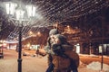 Young couple having fun under holiday winter illumination at night