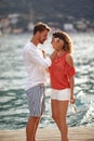 A young couple in love is having romantic moments while walking on the dock on the seaside. Love, relationship, holiday, sea Royalty Free Stock Photo