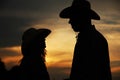 Young couple in love on haystacks in cowboy hats Royalty Free Stock Photo