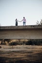 Young couple in love holding hands on an old bridge